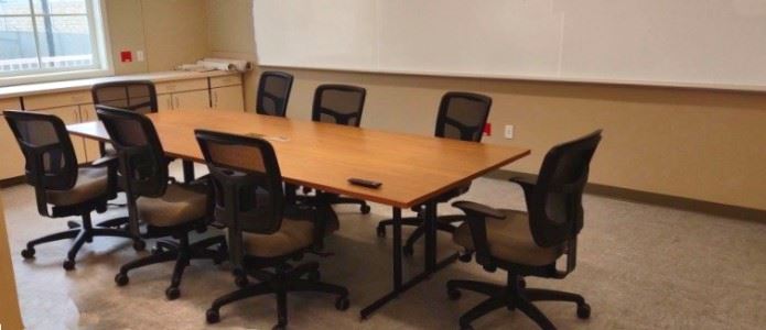 The Garberville Campus Complex Conference Room, with a video screen, meeting table, and chairs.