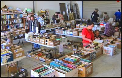 Readers browse boxes of books on tables that fill the big Eureka Library garage.